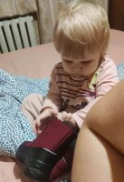 Ребёнок примеряет полученные Ботинки